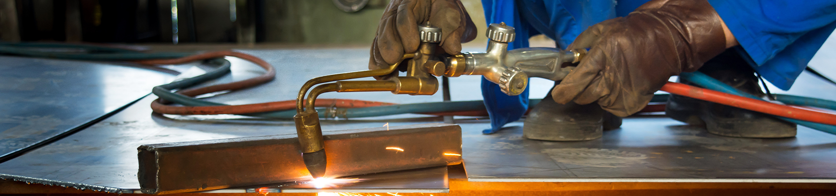 An oxy-acetylene cutting torch is used to cut through sheet metal.